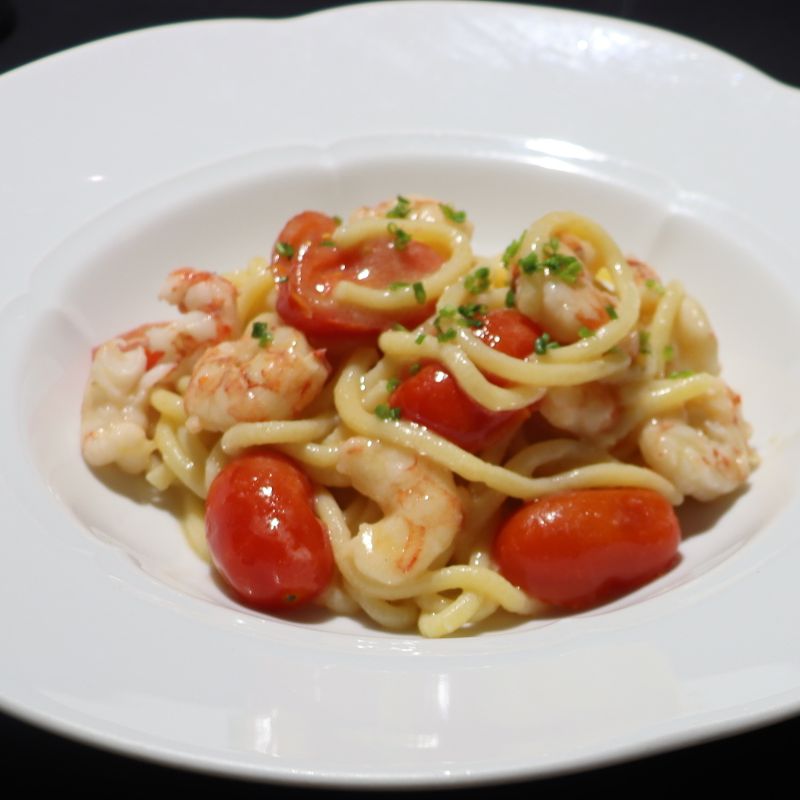 Bigoli with shrimp tails and cherry tomatoes